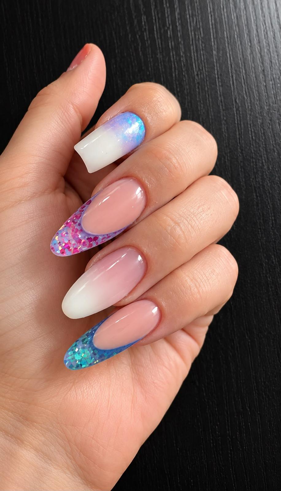 La mano di Diana con unghie rosa e bianche, riflessi lilla e glitter azzurro